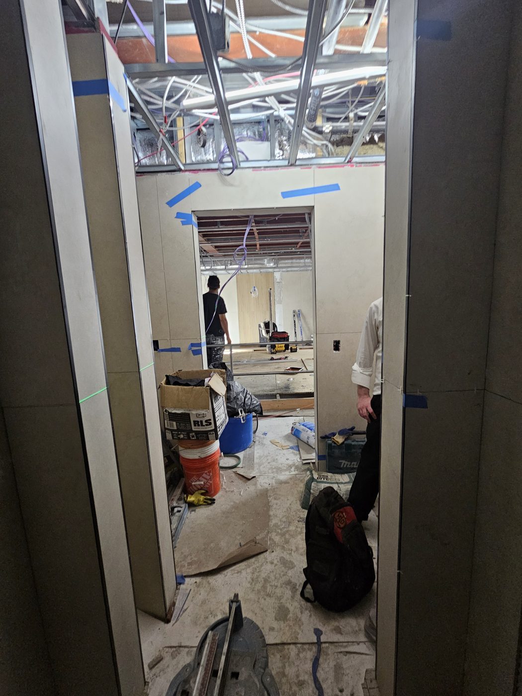 Bathroom corridor at 2555 Nostrand Avenue, Midwood, porcelain panels set and door opening being surveyed