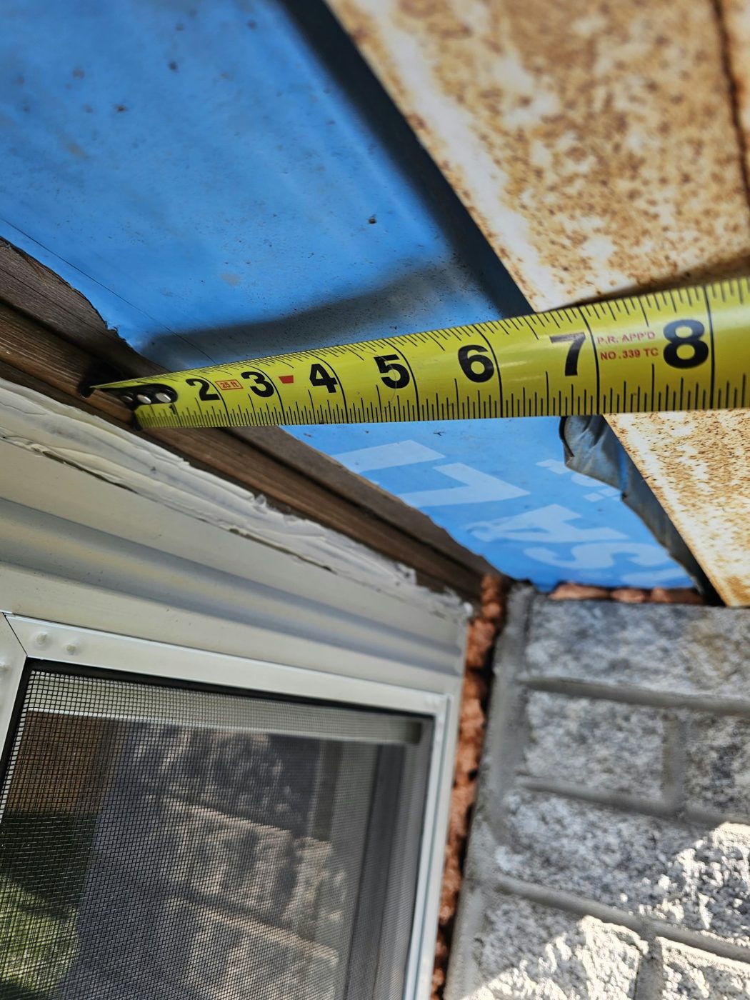 Tape measure across exposed blue waterproofing membrane above a window head at 5101 Beach 51st Street, Sea Gate, Brooklyn