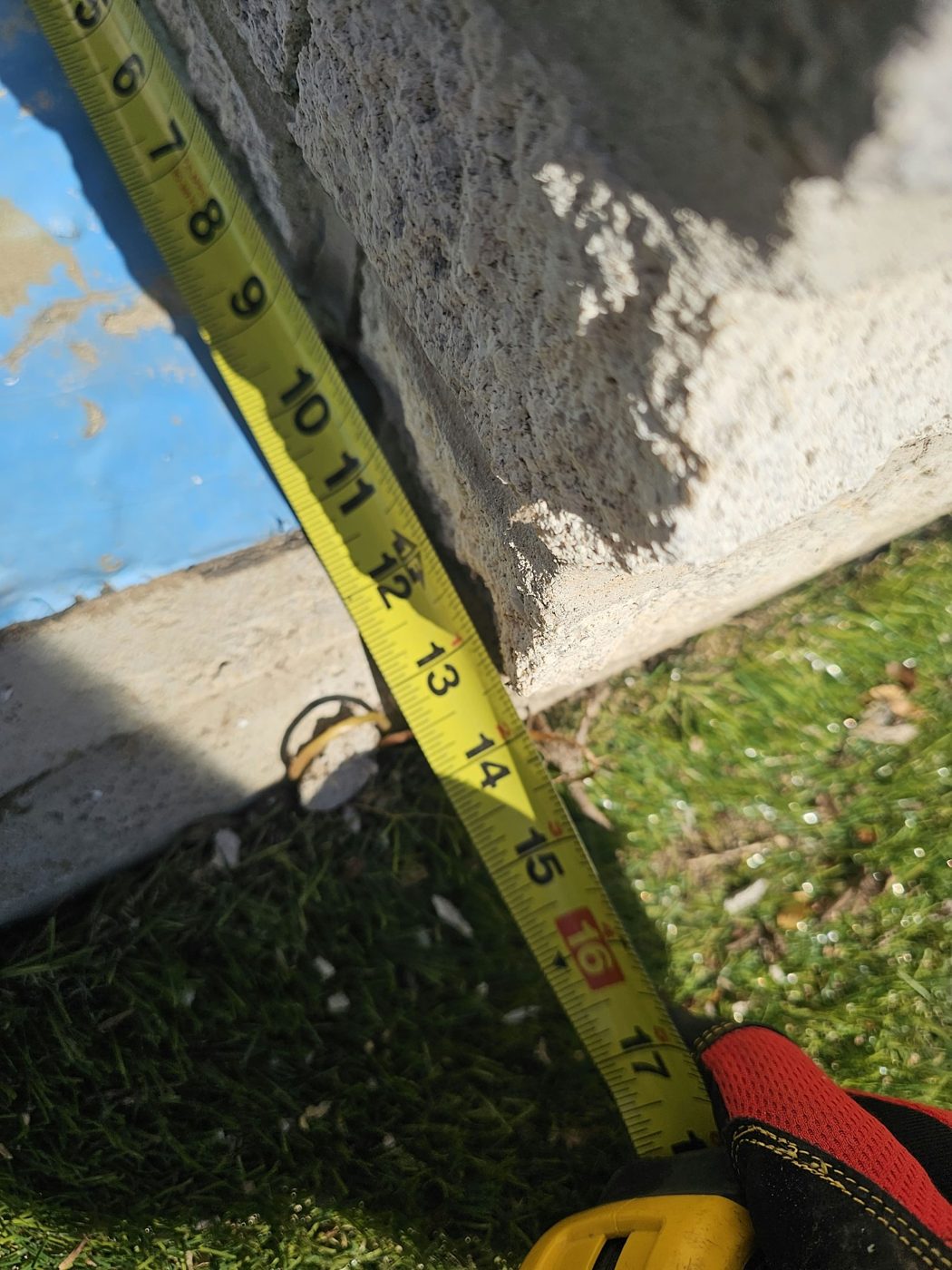 Tape measure against exposed blue waterproofing membrane at the base of the wall at 5101 Beach 51st Street, Sea Gate