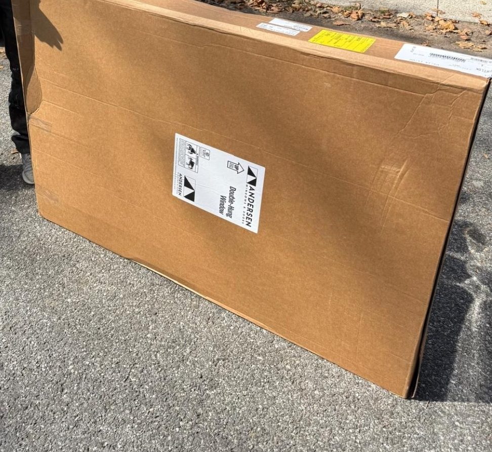 A made-to-order window delivered in its carton from a direct window supplier, ready to be carried to the opening