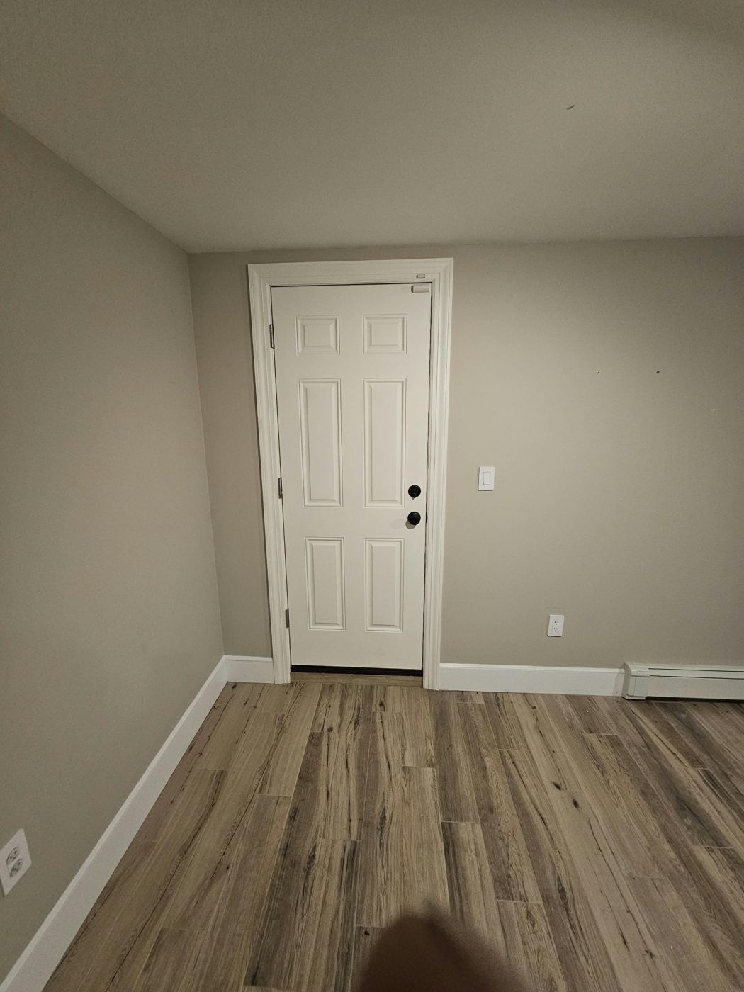 Existing white six-panel door seen from inside a finished room