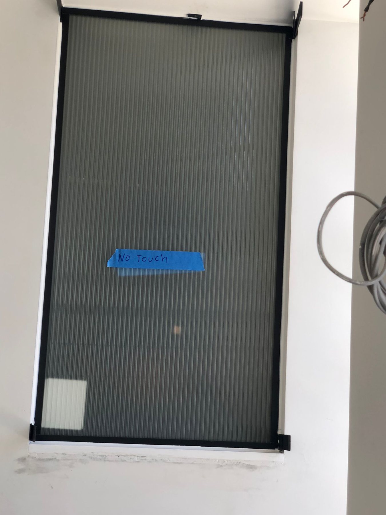Interior reeded fluted glass panel in a slim black frame, transmitting daylight while obscuring the view