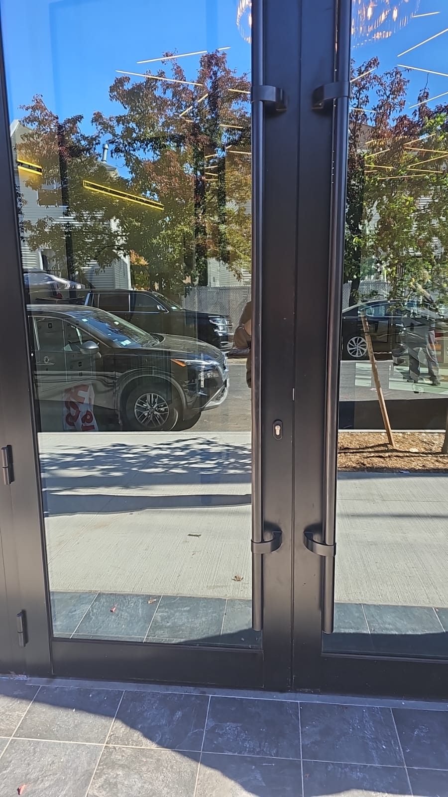 Close view of custom 7-foot black offset ladder pull handles on the main entrance doors at 217 Main Street, Staten Island