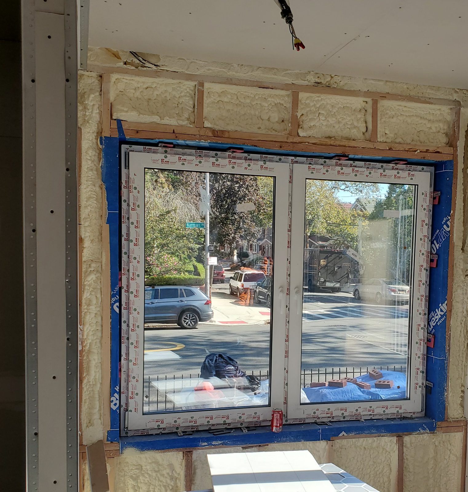 Interior view of a two-part uPVC window with waterproofing membrane and spray foam insulation around the opening at 24 74th Street, Brooklyn