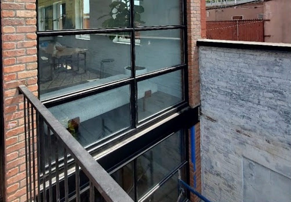 Exterior view of gridded steel windows with insulated glass set in the brick wall at 266 Bond Street, Brooklyn