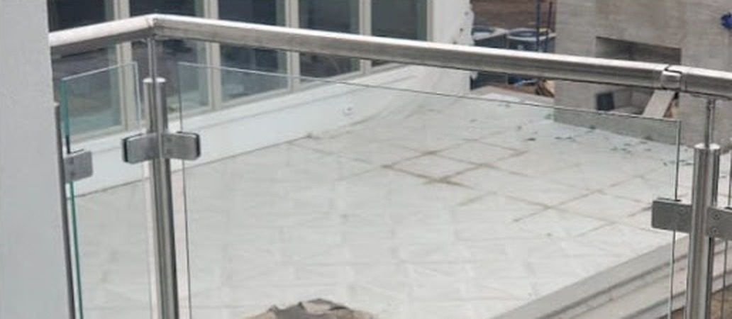 Stainless steel top rail, posts and glass clamps of the balcony railing at 27 Runyan Avenue, Deal, NJ