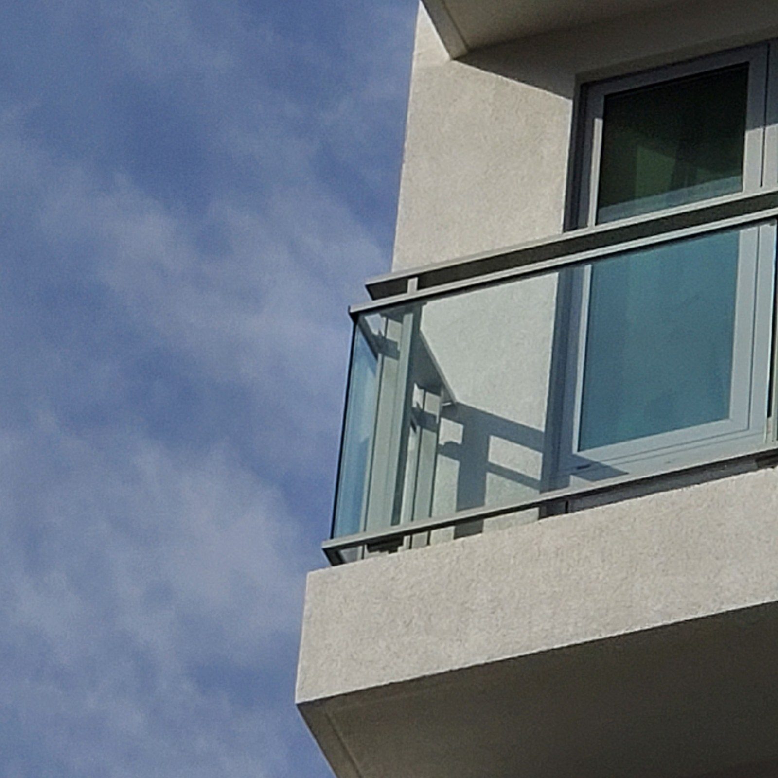 Close-up of the aluminum top rail, post and glass panel of the Aluminco balcony railing at 42-44 Crescent