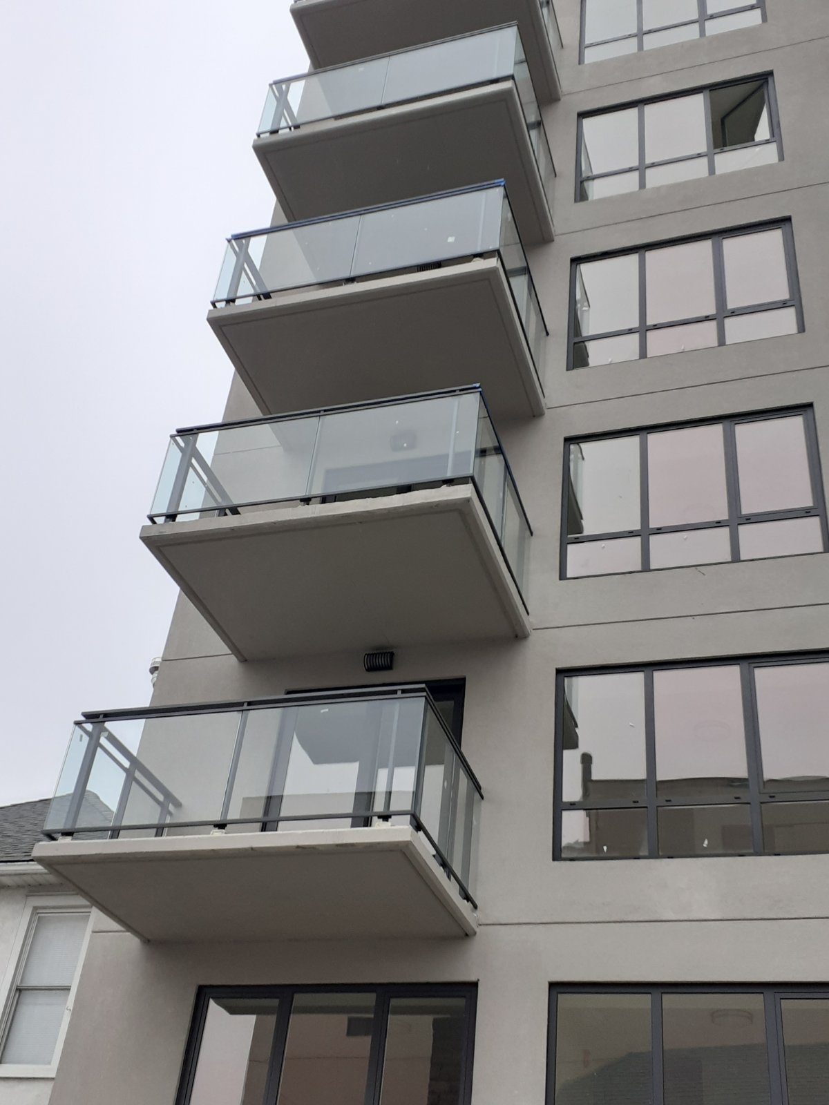 Glass balcony railings in an aluminum frame on projecting balconies at 42-44 Crescent