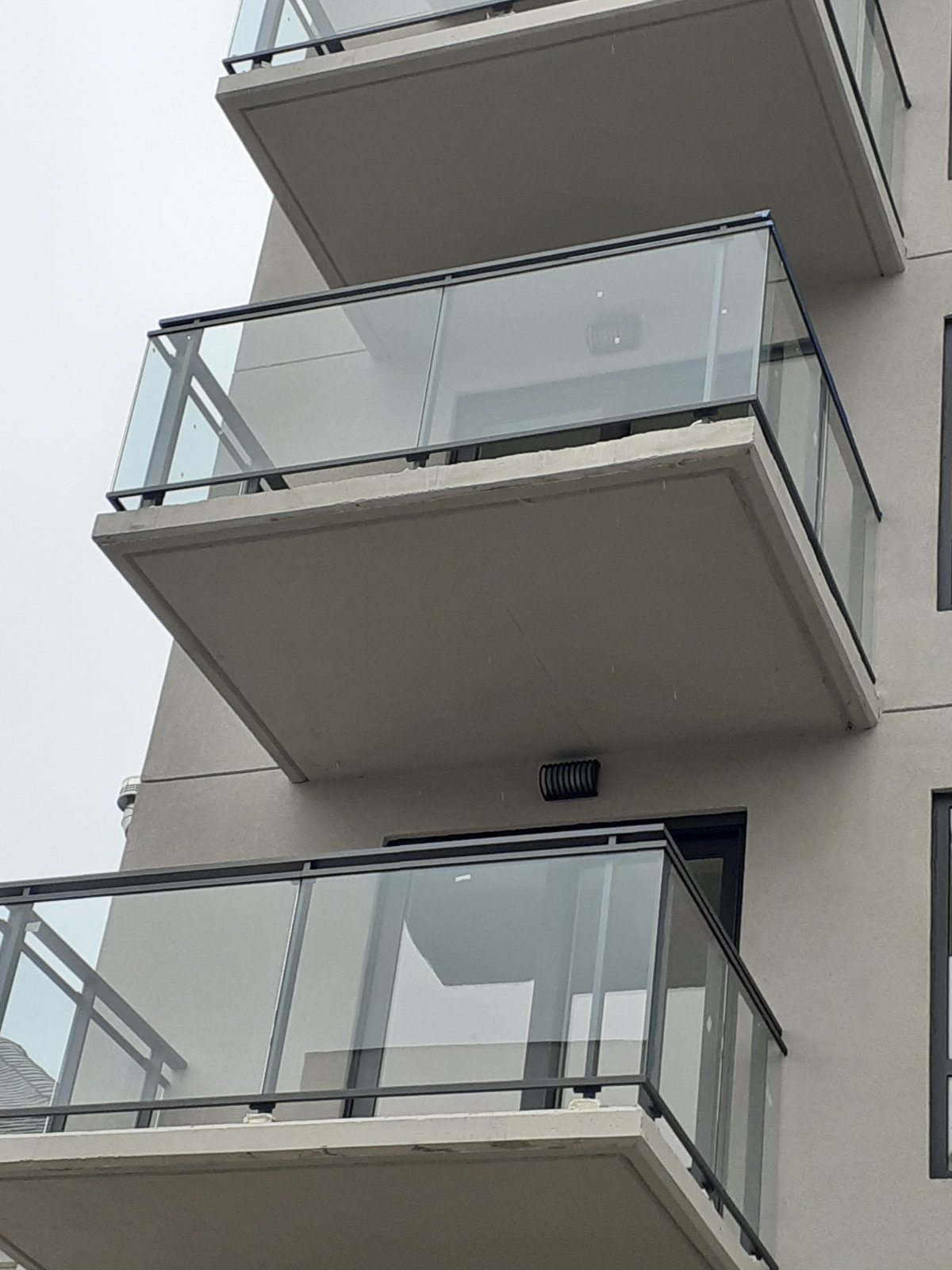 Detail of glass panels in the aluminum balcony railing at 42-44 Crescent, seen from below