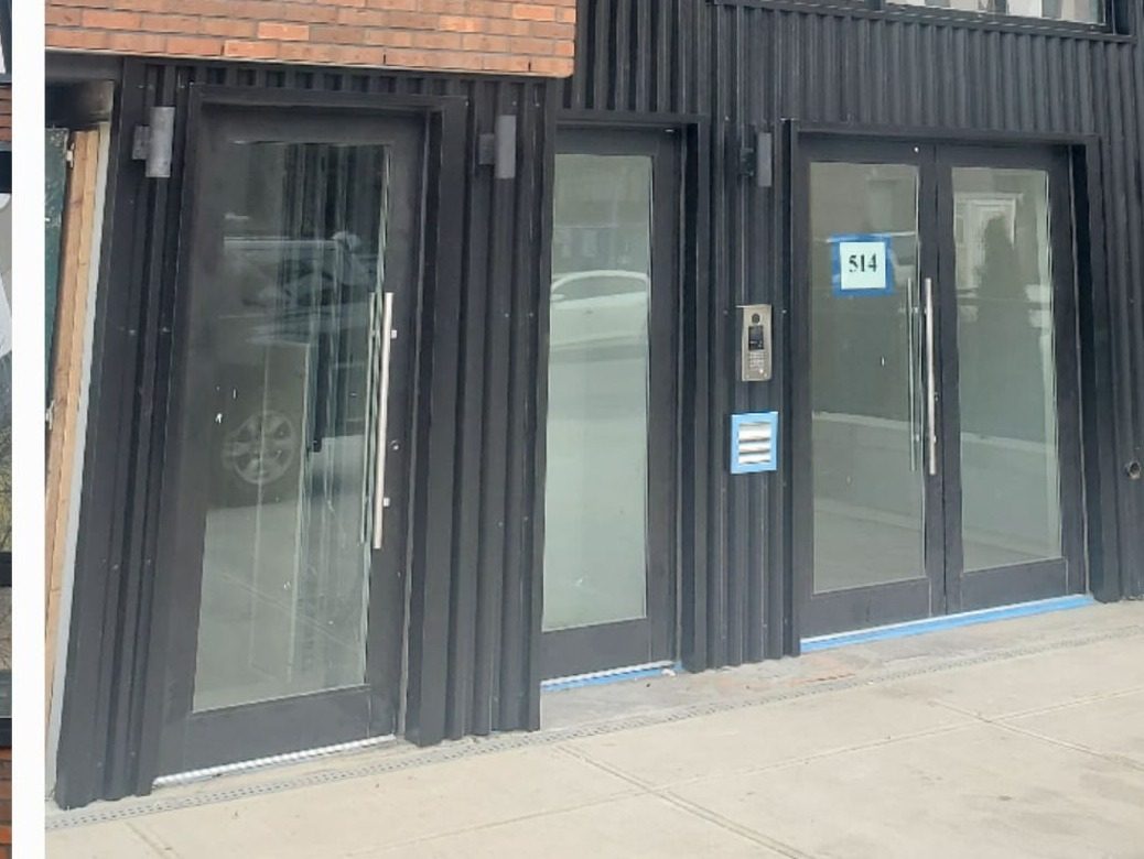 Commercial storefront double doors with pull handles set in black ridge panels at 514 Herkimer Street, Brooklyn