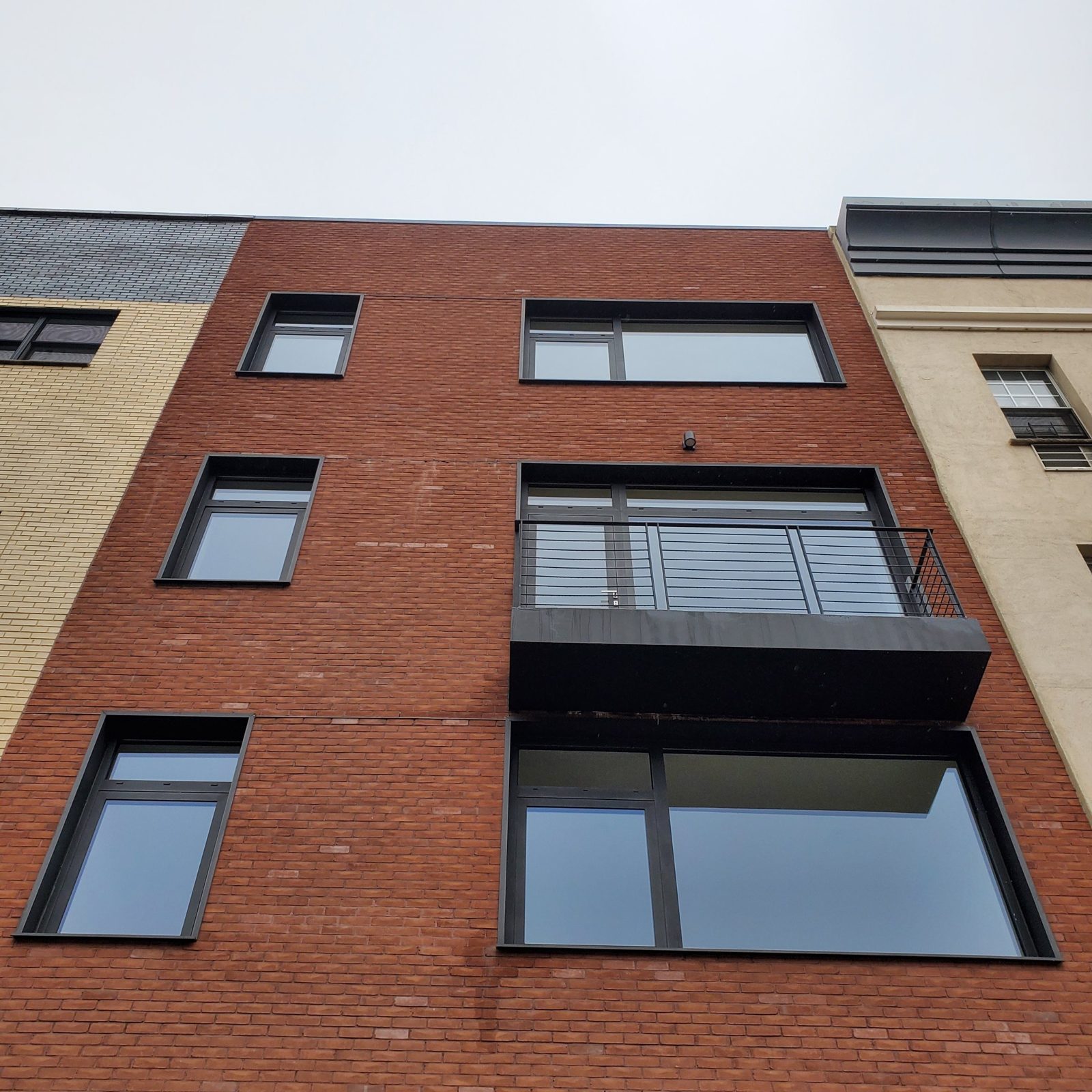 Reynaers aluminum windows in deep dark metal surrounds on the brick facade of 538 5th Avenue, Brooklyn