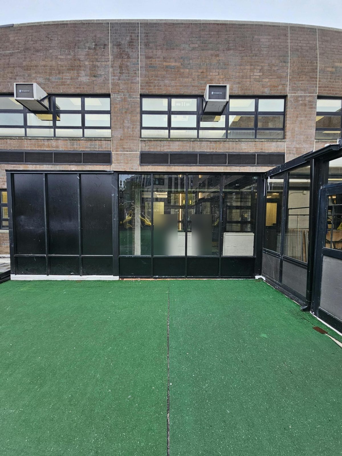 Custom black aluminum and glass enclosure with solid panels on the front outdoor deck of 590 Bedford Avenue, Williamsburg, Brooklyn