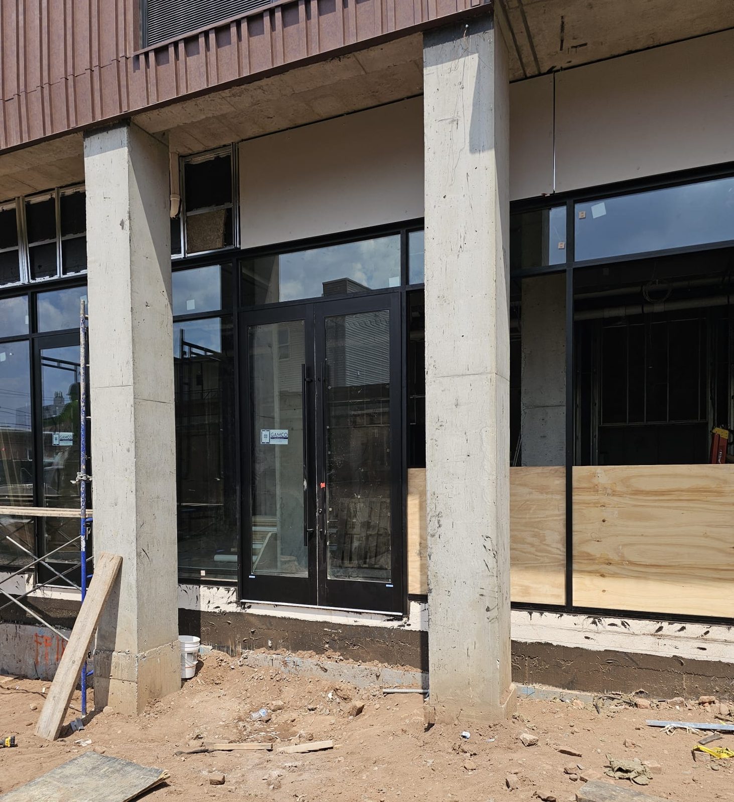 Pair of Gamco aluminum storefront entrance doors set between concrete columns at 66 McWhorter Street, Newark