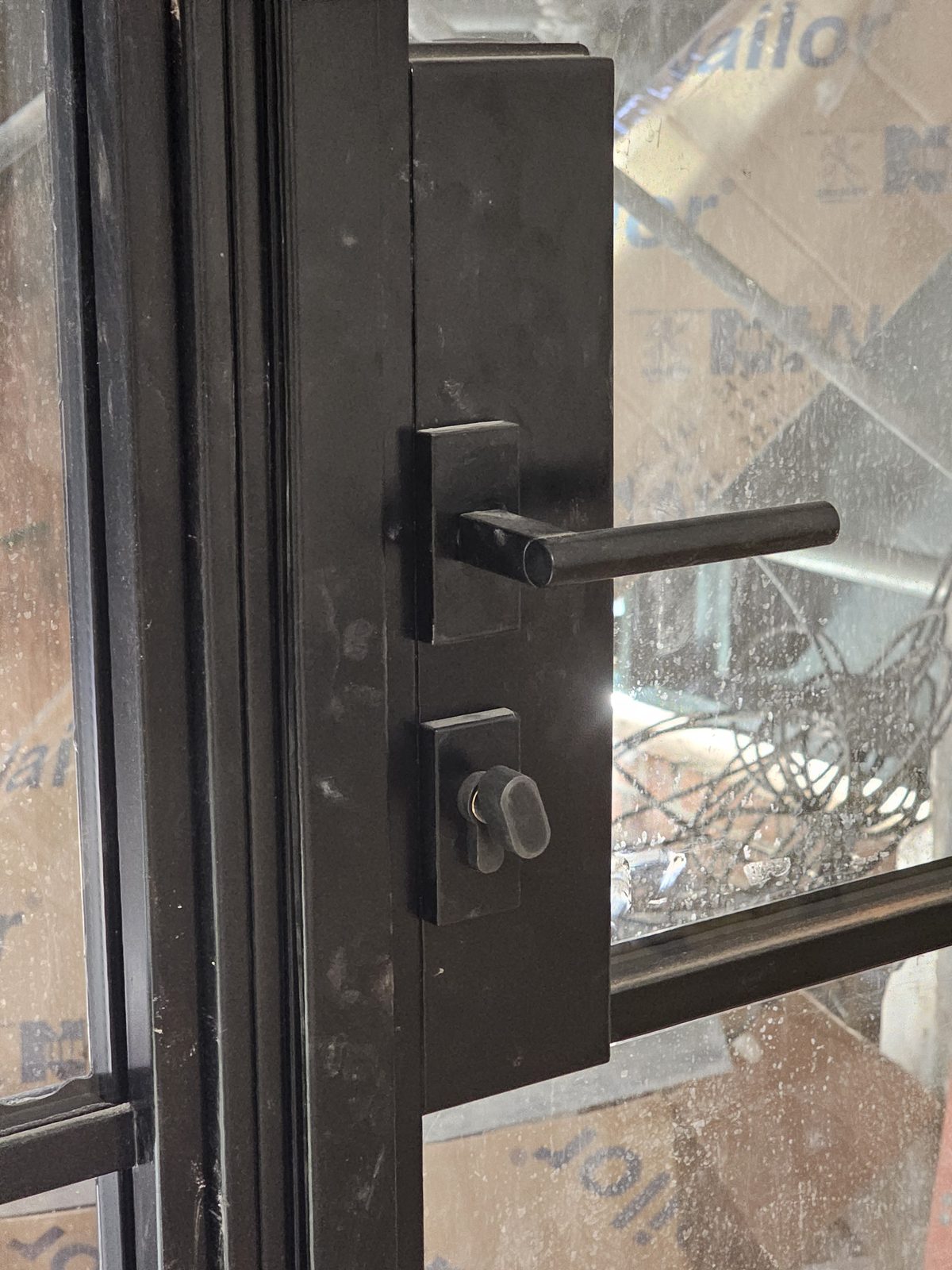 Close view of the black lever handle and lock on a SIMPAS in-swing door