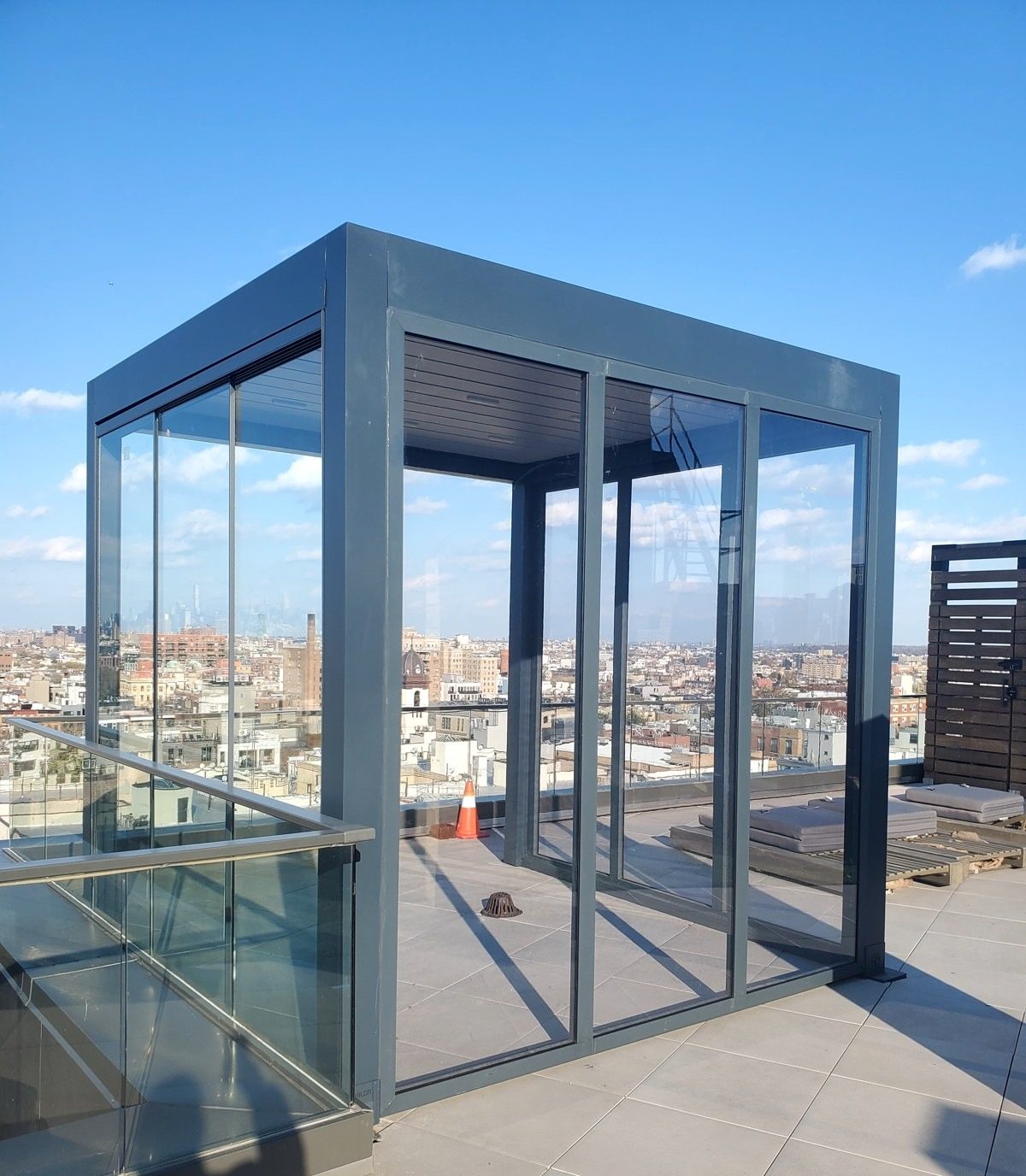 Dark gray aluminum pergola sunroom with glass walls on the roof terrace at 86 Washington Avenue, Brooklyn
