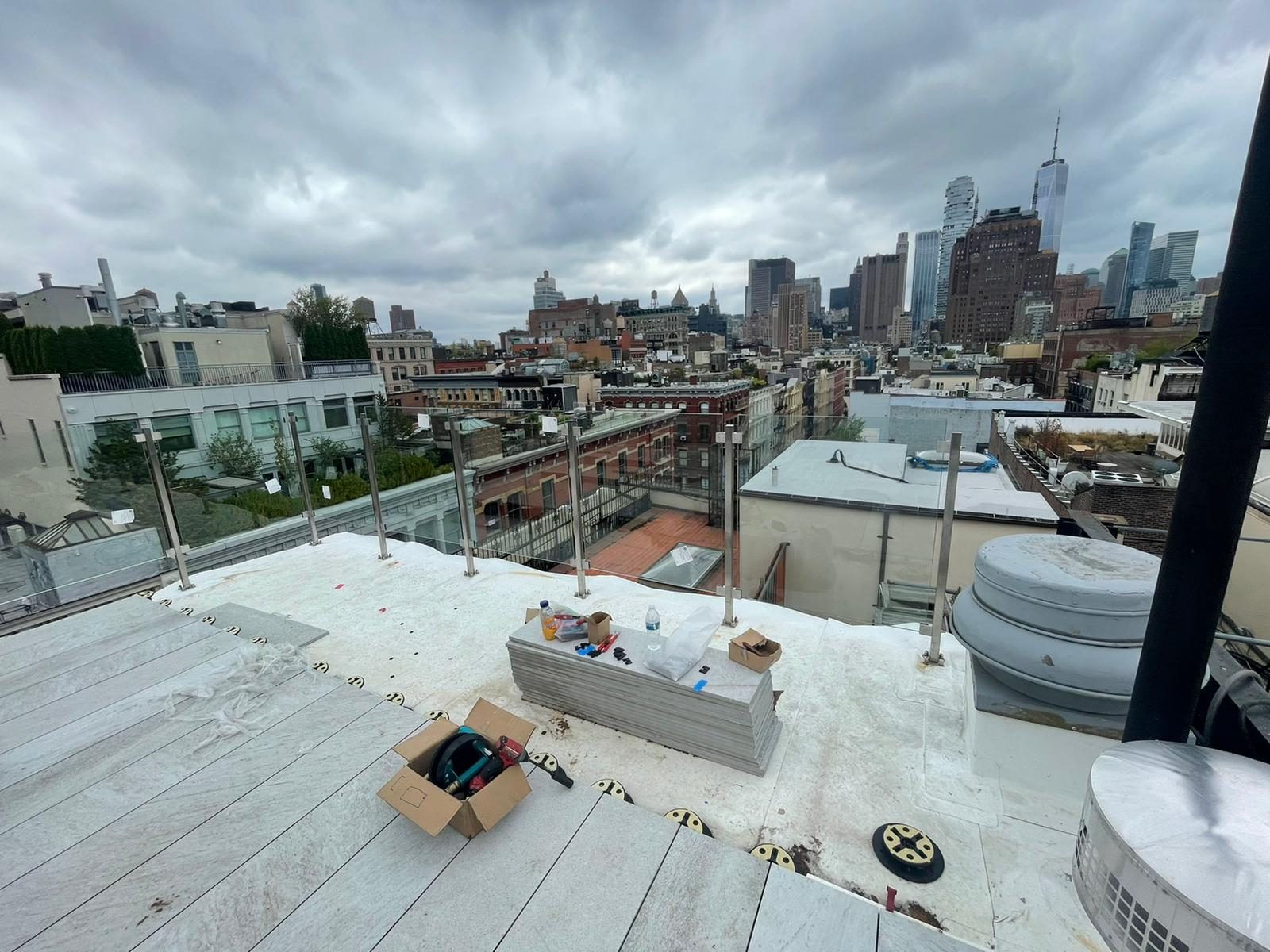 Stainless steel post and glass railing around the roof terrace at 95 Greene Street, SoHo, with the Lower Manhattan skyline beyond