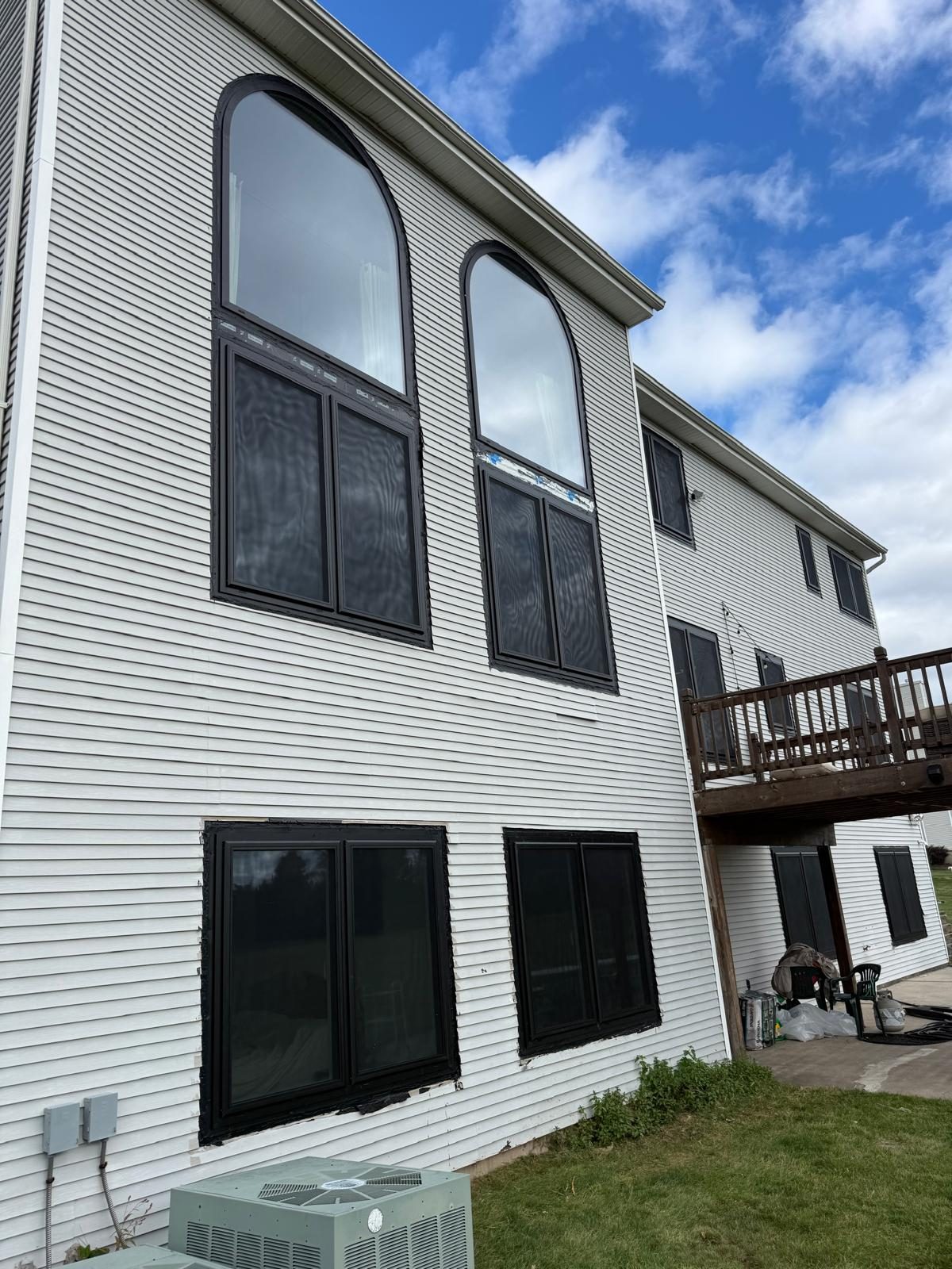 Two tall arched black aluminum windows above paired windows on the side of the house in Somerset, NJ