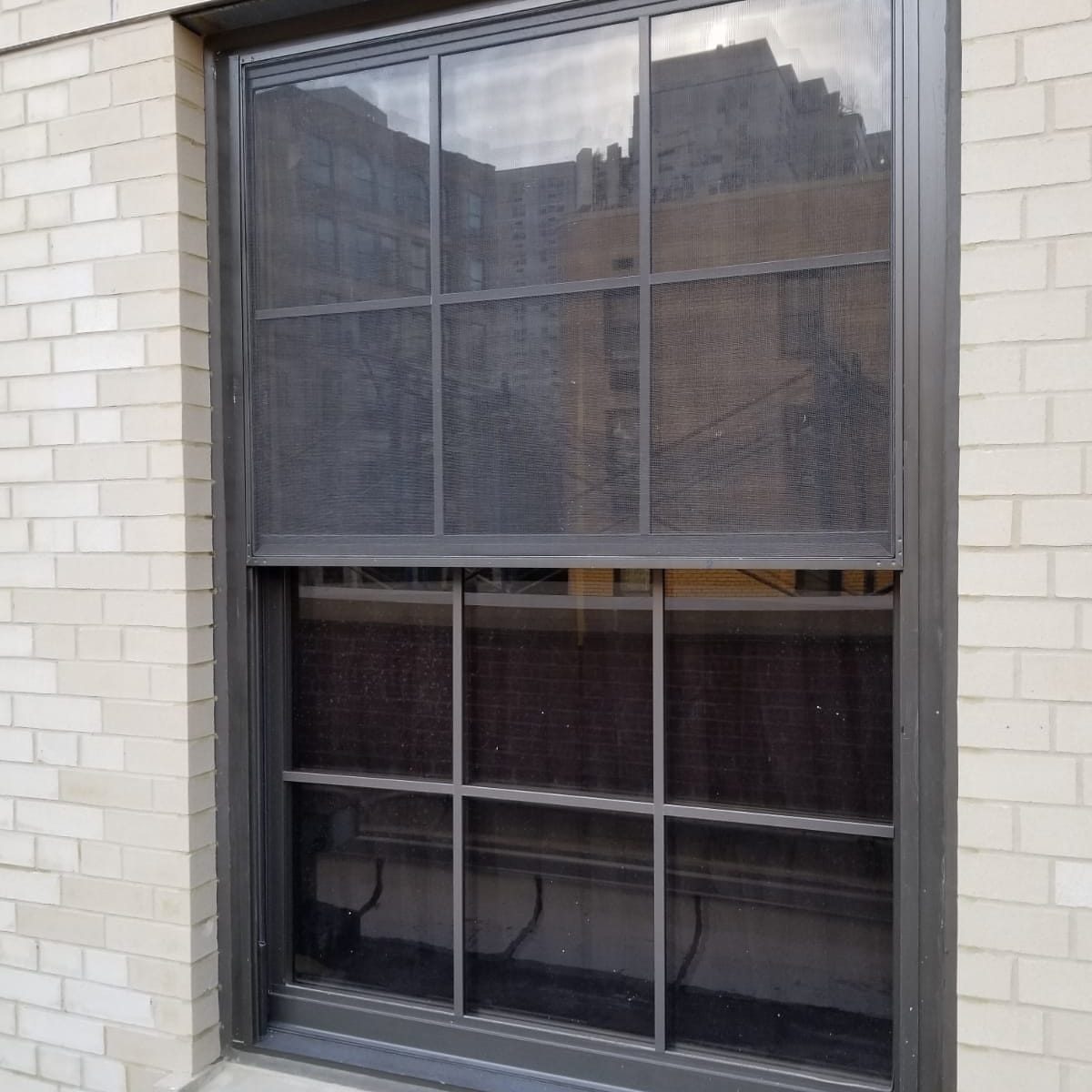 Dark bronze double-hung replacement window with the insect screen at the upper sash, U.S. Post Office near Webster Hall, Manhattan