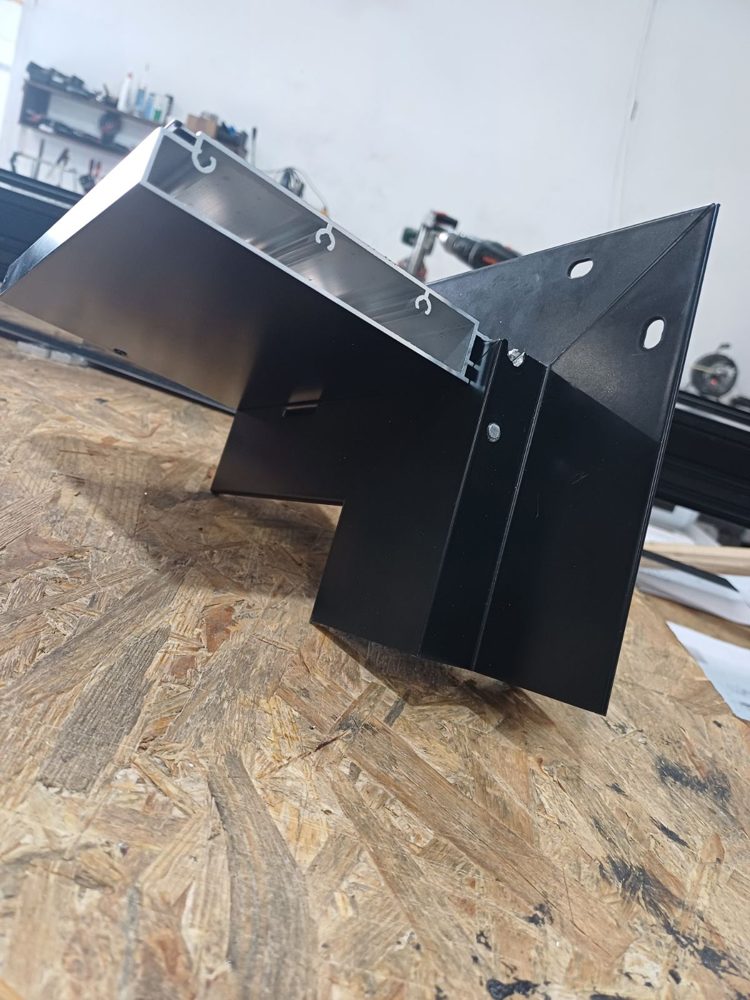 Corner sample of a black aluminum window frame showing the flat nail fin with slotted holes and the exterior fin for a brick finish