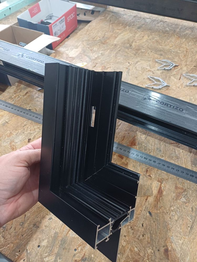 Interior side of a mitered corner sample of a black thermally broken aluminum window frame