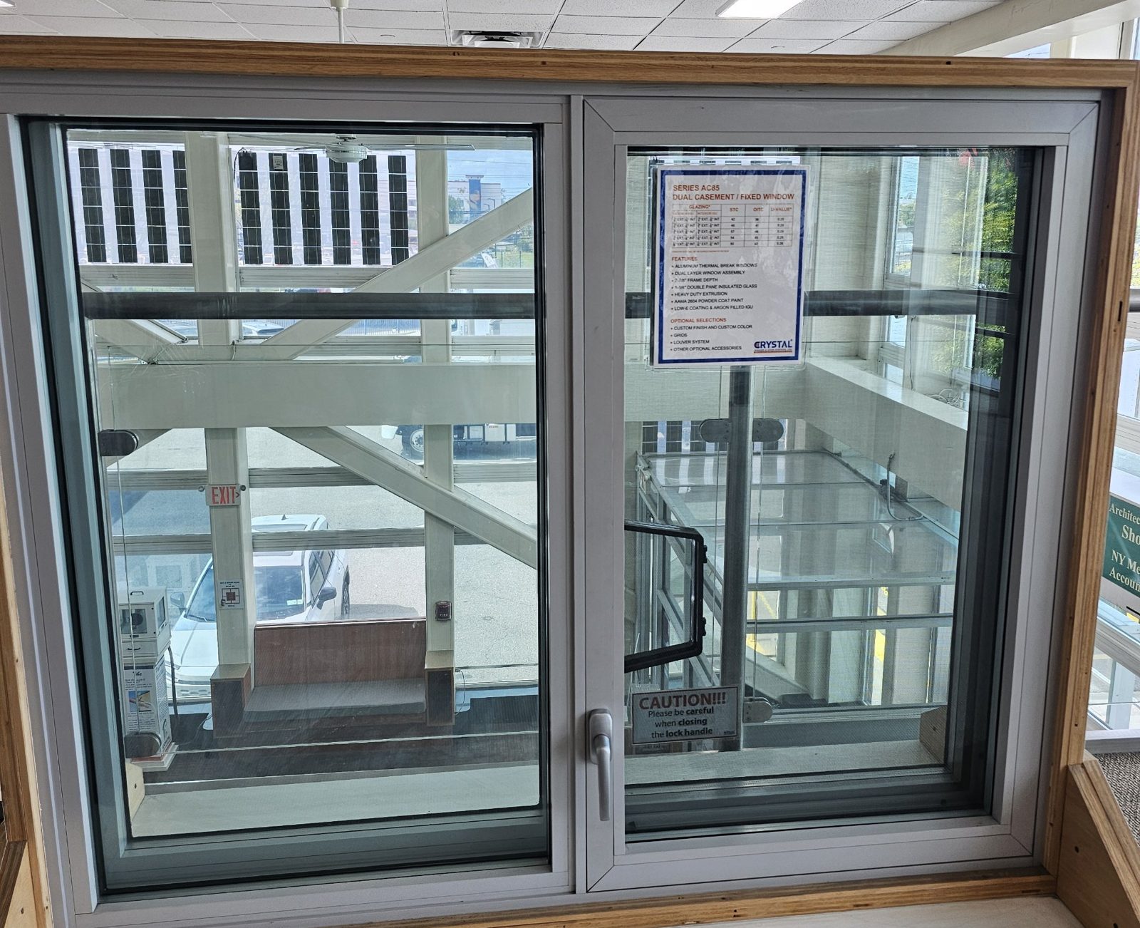 Crystal Series AC85 dual-layer acoustic window sample: a fixed lite beside a casement, two glazed layers in one deep white aluminium frame with a lever handle