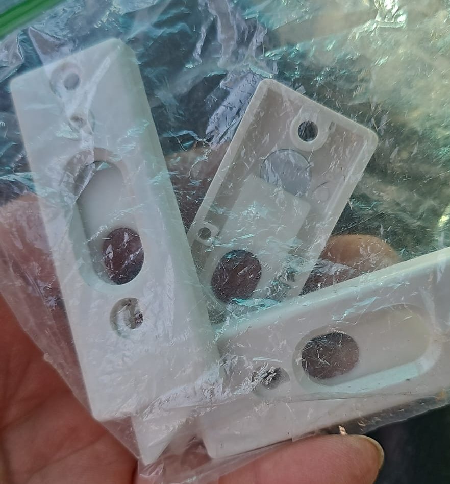 Three white plastic tilt latches for a double-hung window, in a parts bag